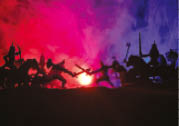 Medieval battle scene with cavalry and infantry. Silhouettes of figures as separate objects, fight between warriors on dark toned foggy background. Night scene. Selective focus