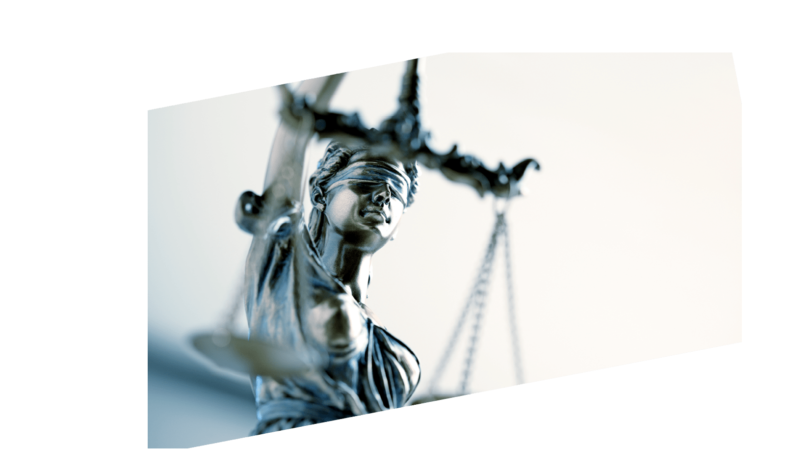 A close up and a low angle view of a statue of lady justice. The image is photographed with a very shallow depth of field with the focus being on her face.
