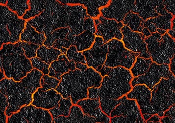 Red hot lava through the cracked ground background. Magma texture and the black burned ground. Active volcano surface.
