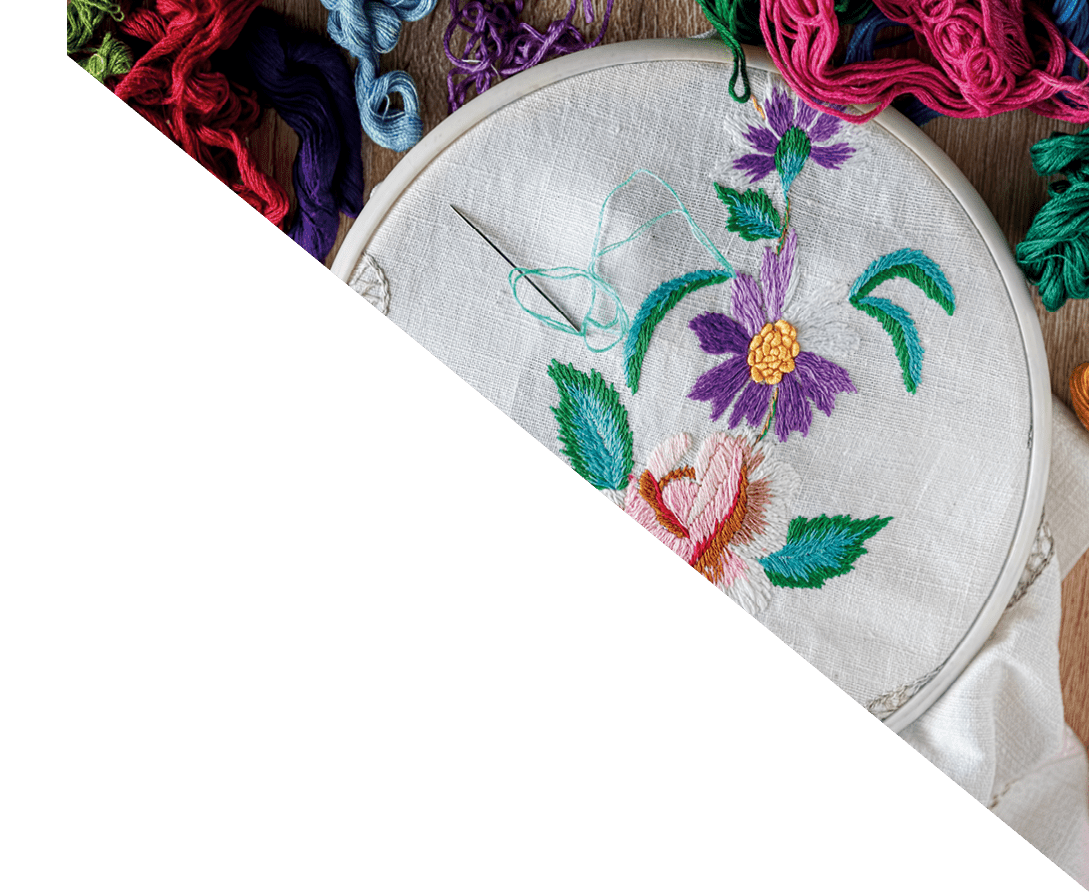 embroidery hoop with floral embroidery. floss threads around. top view.